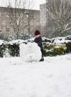 Menino boneco de neve edifício no parque — Fotografia de Stock