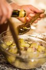 Mains masculines verser de l'huile d'olive dans la salade — Photo de stock
