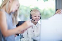 Smiling boy in headset on background of children — Stock Photo