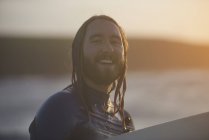 Porträt eines jungen männlichen Surfers mit Surfbrett, devon, england, uk — Stockfoto