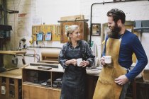 Ремесленник и женщина беседуют в трубной мастерской — стоковое фото