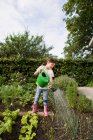 Mädchen gießt Pflanzen im Hinterhof — Stockfoto