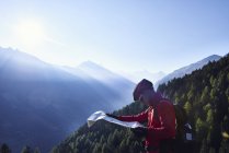 Mountain biker holding map, Valais, Switzerland — Stock Photo