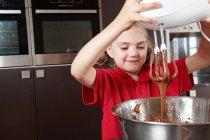 Girl making cake with mixing bowl — Stock Photo