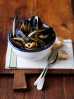 Bowl of peppered mussels and bread — Stock Photo