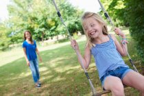 Girl playing on swing in backyard, selective focus — Stock Photo