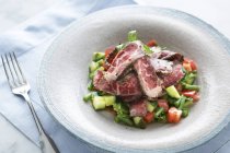 Fette di carne con insalata sul piatto — Foto stock