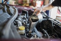 Mechaniker schüttet Flüssigkeit ins Auto — Stockfoto