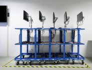 Computer monitors on blue rolling carts — Stock Photo