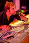 Young man working on mixing desk — Stock Photo