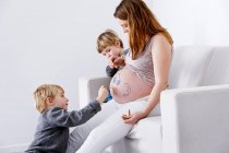 Children drawing on pregnant mother — Stock Photo