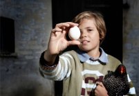 Хлопчик тримає яйце і курку на відкритому повітрі — стокове фото