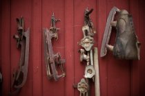 Oldtimer-Schlittschuhe hängen an roter Wand — Stockfoto