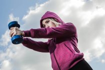 Молодая женщина с помощью гирь для рук — стоковое фото