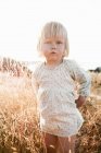 Toddler girl standing in wheatfield — Stock Photo