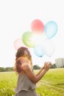 Donna con palloncini d'aria nei prati — Foto stock