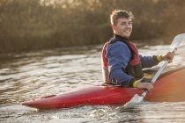 Young man rowing in kayak — Stock Photo