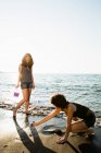 Mujeres jugando juntas en la playa - foto de stock