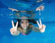 Menina sorridente brincando na piscina — Fotografia de Stock