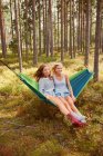 Mujeres relajándose en hamaca en el bosque - foto de stock