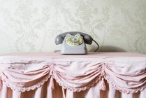 Vintage telephone on frilly tablecloth — Stock Photo