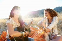 Женщины, играющие на гитаре в траве — стоковое фото