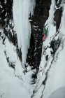 Escalador com picaretas descendo colina nevada — Fotografia de Stock