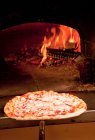 Koch zieht Pizza aus dem Ofen — Stockfoto
