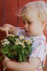 Девушка трогает горшок растения на открытом воздухе — стоковое фото