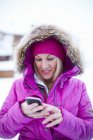 Жінка використовує мобільний телефон взимку — стокове фото
