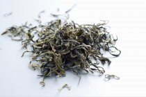 Чай листья кучи на белом — стоковое фото