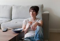 Woman watching television with dinner — Stock Photo