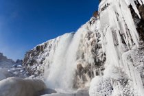 Wasserfall und Eiszapfen an Klippen — Stockfoto