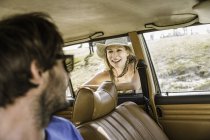 Man chatting up woman at car window on coast road, Cape Town, South Africa — Stock Photo