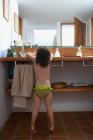 Rear view of girl washing hands in bathroom — Stock Photo