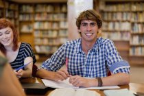 Estudantes estudando juntos na biblioteca — Fotografia de Stock