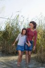 Madre e figlia che camminano nello stagno — Foto stock