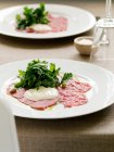 Carpaccio with salads on plates — Stock Photo