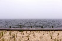 Морський пейзаж з пляжем і дерев'яною дошкою — стокове фото