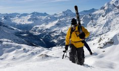 Двоє чоловіків лижники піднімаються на гору — стокове фото