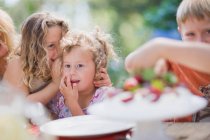 Smiling girls whispering at table — Stock Photo