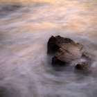 Roca en el mar a niebla - foto de stock