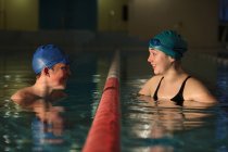 Swimmers talking in pool lanes — Stock Photo