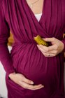 Pregnant woman eating pickle — Stock Photo