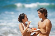 Casal comendo juntos na praia — Fotografia de Stock