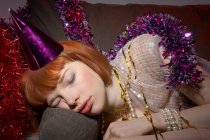 Жінка з вечірнім капелюхом спить на дивані — стокове фото