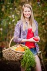 Frau sammelt Gemüse im Garten, Fokus auf den Vordergrund — Stockfoto