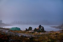 Hikers relaxing in camp near lake, Lapland, Finland — Stock Photo