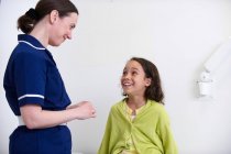Enfermera y niña sonriendo - foto de stock