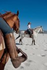 2 pessoas montando cavalos na praia — Fotografia de Stock